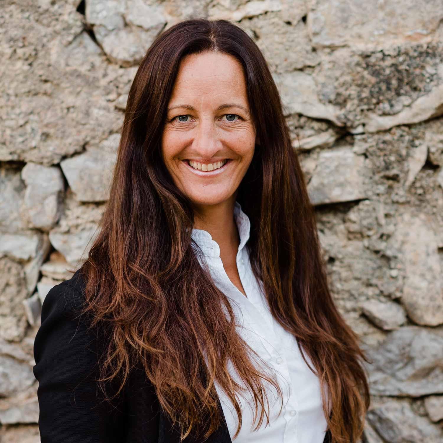 Die Expertin für Beratermarketing und Bewusstheit im Business Nadine Hamburger vor einem Segelboot und lächelt in die Kamera.